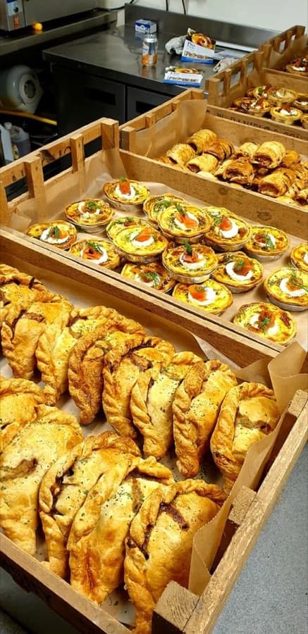 Crates of pasties, mini quiches and sausage rolls ready for a market day