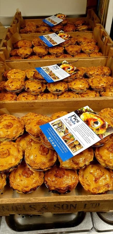Stacked wooden crates of individual savoury pies ready to collect